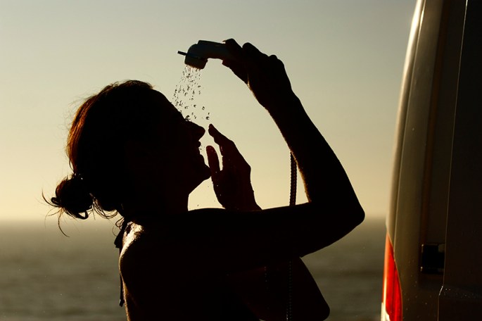 women taking an outside shower by the sea